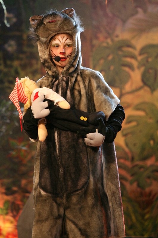 Der Panther Drüggela (Jovina Fischer) bringt das kleine Hänneschen zur Wolfsmutter (Man beachte die Kölsche Mütze), Foto: Kemper