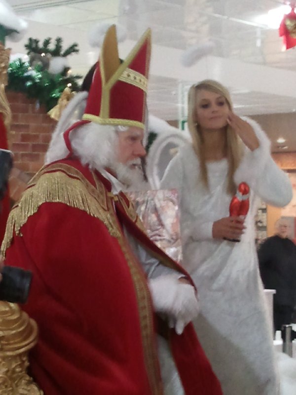 Wohltätiger Nikolaus mit Engel in einem Einkaufscenter
